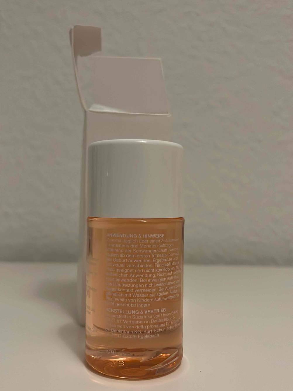 Rückseite der getesteten Dehnungsstreifen-Creme vor einer hellen Wand.