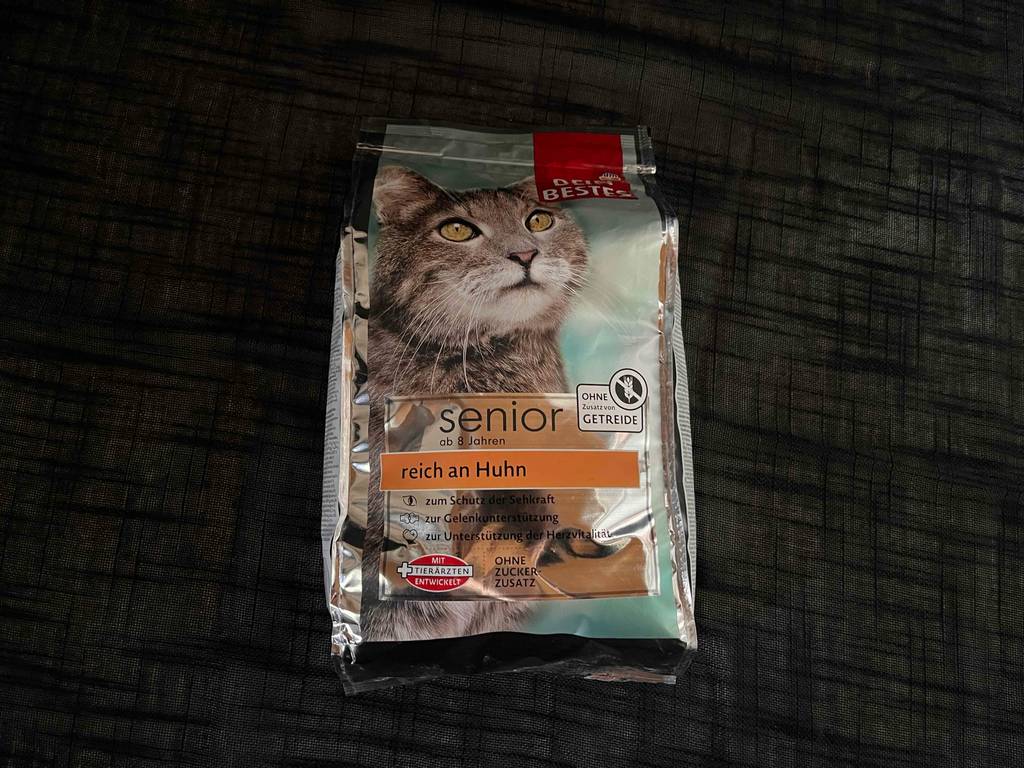Eine Packung Katzen-Trockenfutter liegt zum Testen auf einer dunklen Fläche.