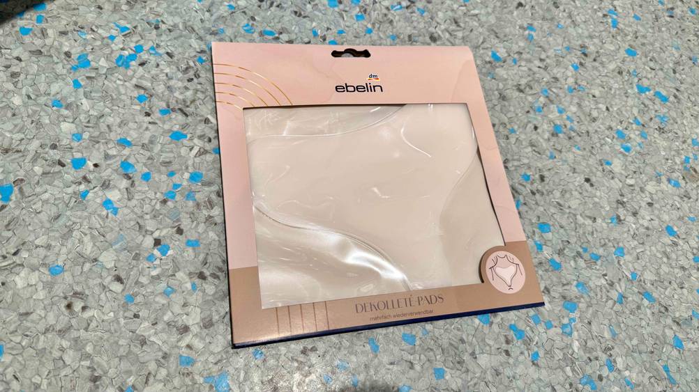 Dekolleté-Pads im Test: Eine Packung liegt auf einem grau-blauen Boden.