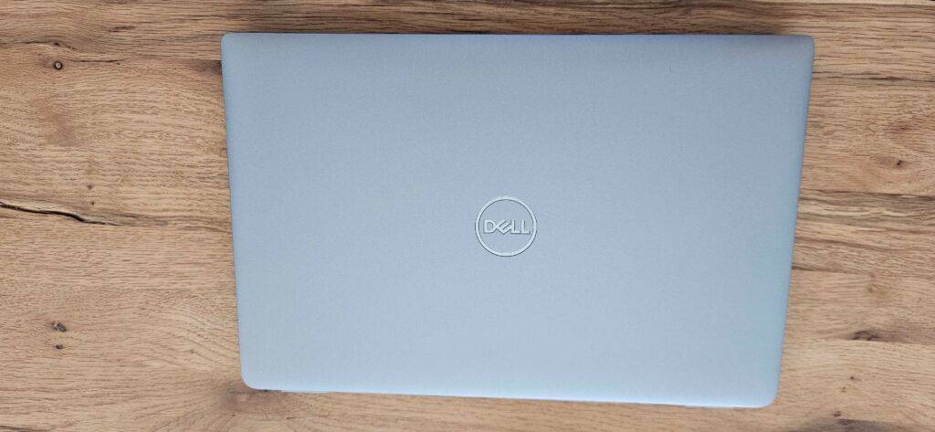 Ein zugeklapptes Dell-Laptop steht zum testen auf einer Holzfläche.