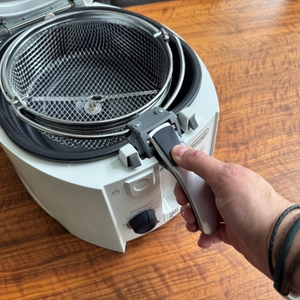 Eine Hand hält den Griff des Korbs der DeLonghi F 28311 fest