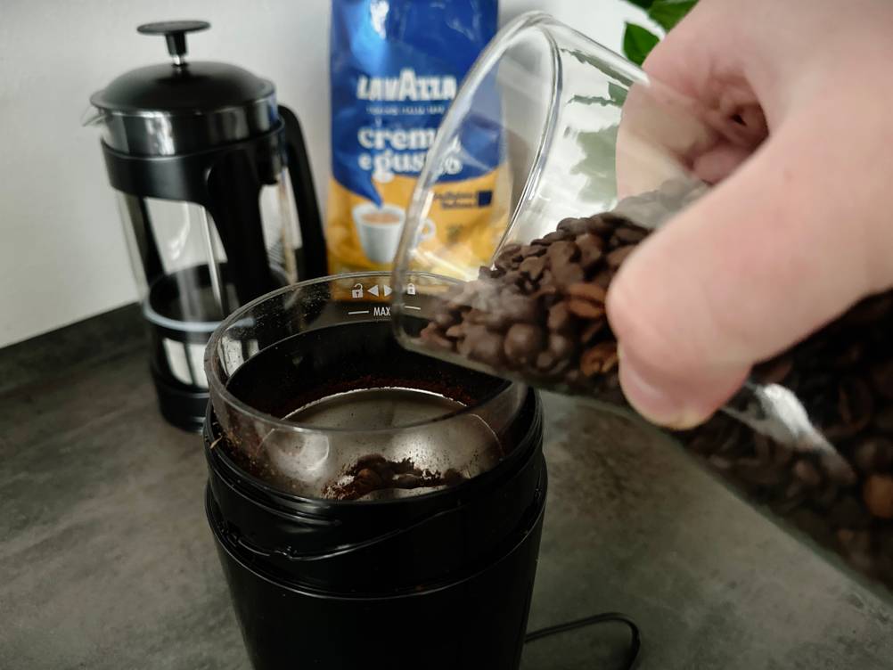 Kaffeemühlen im Test: Eine De'Longhi KG210 wird mit Bohnen befüllt.