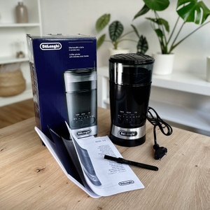 Kaffeemühlen im Test: Lieferumfang der De'Longhi-Kaffeemühle auf einem Tisch.
