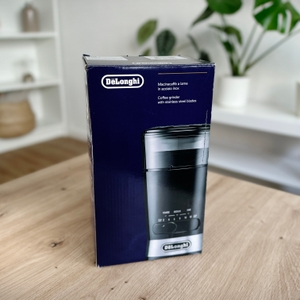 Kaffeemühlen im Test: Verpackung der De'Longhi-Kaffeemühle auf einem Tisch.