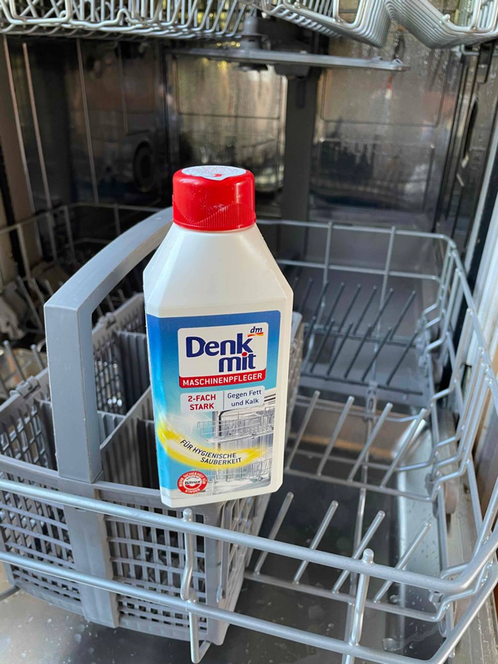 Denkmit-Spülmaschinenreiniger steht in einer Spülmaschine.