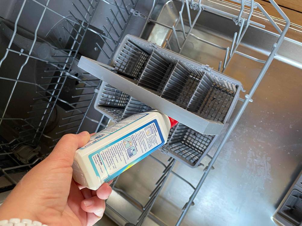 Denkmit-Spülmaschinenreiniger wird in den Besteckkorb gehalten.