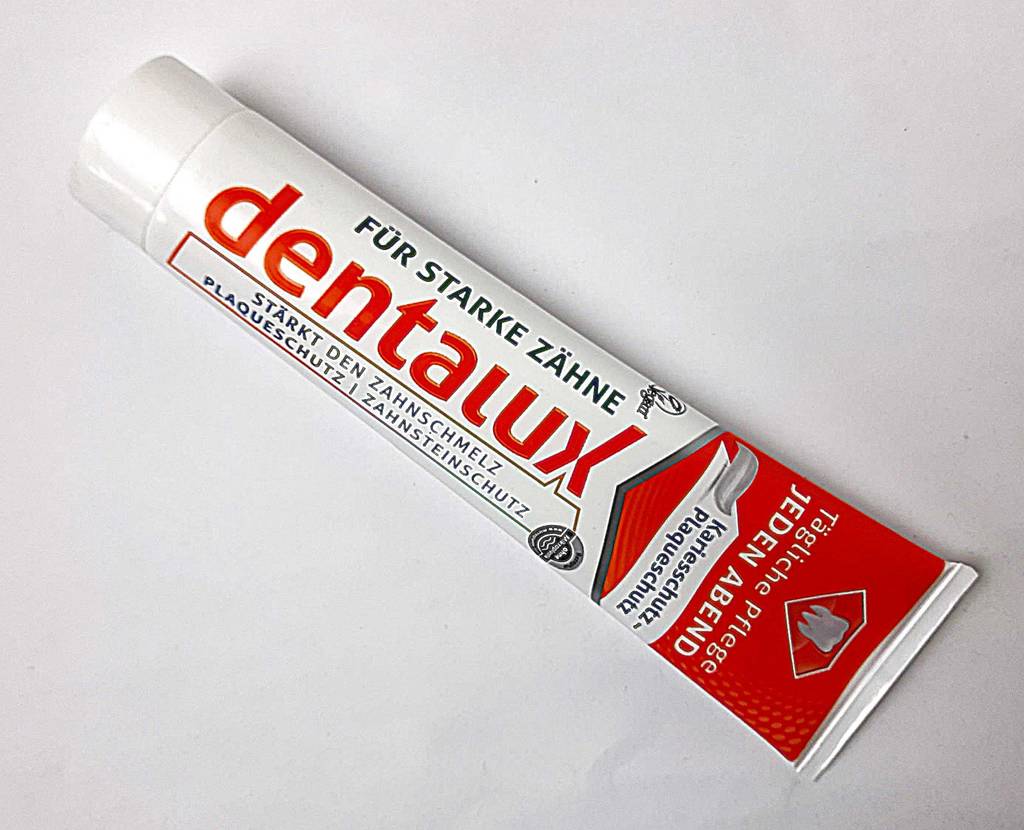 Eine Tube mit remineralisierender Zahncreme im Test liegt auf einer weißen Oberfläche.