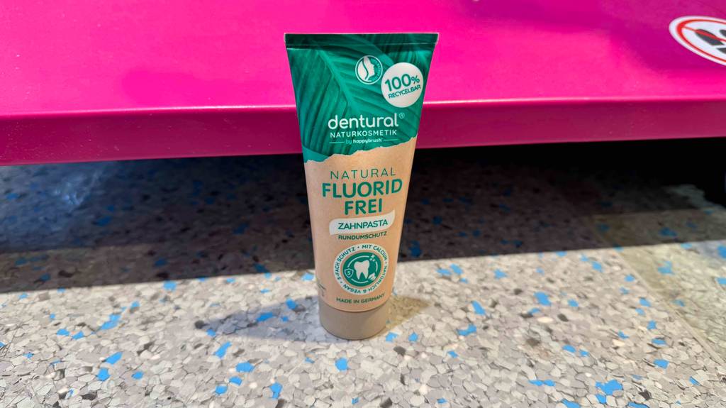 Im Test: Zahnpasta ohne Fluorid in der Tube steht vor einem Verkaufsregal.