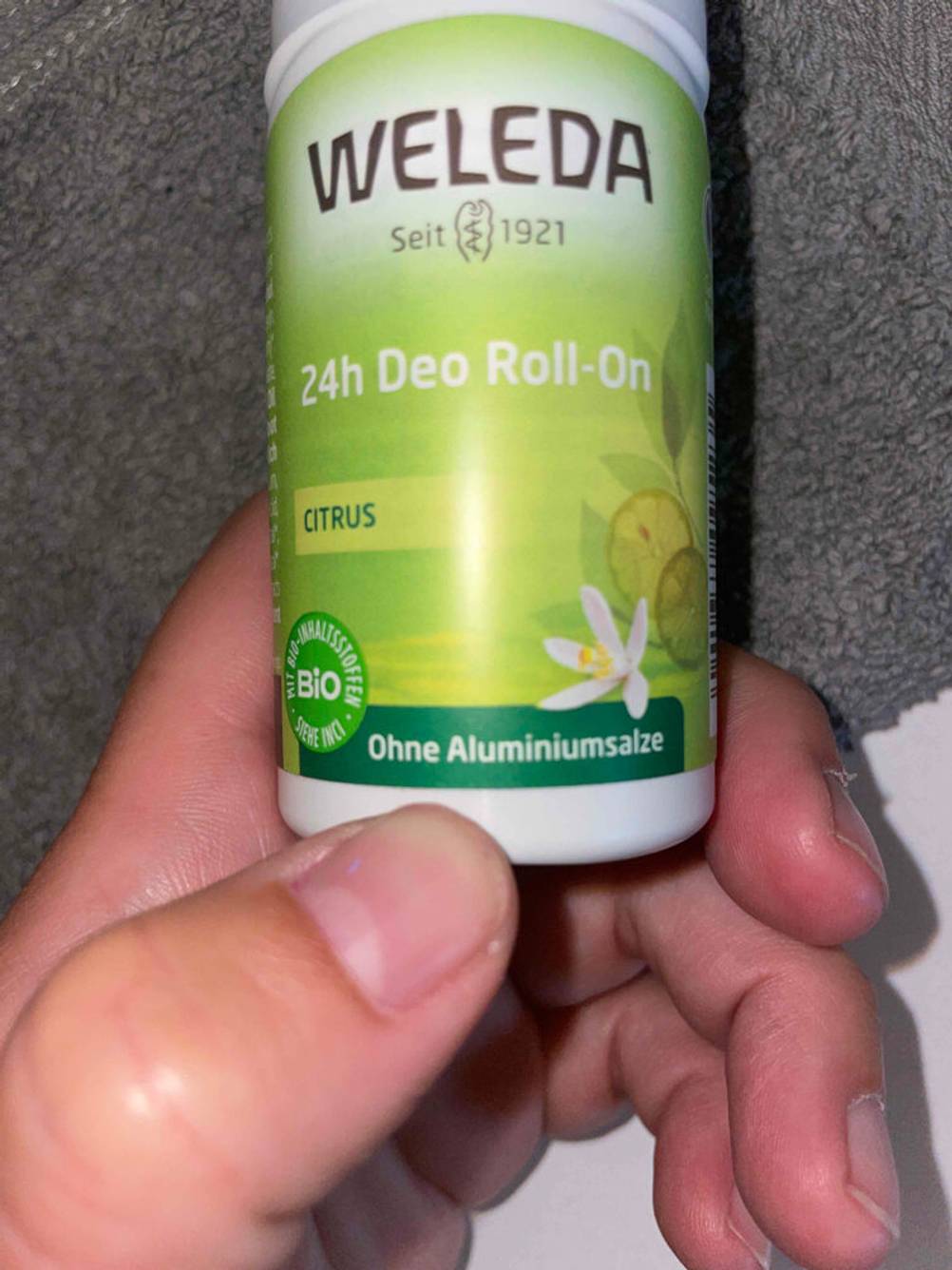 Nahaufnahme des Labels auf der Vorderseite eines Deo-Rollers für Damen von einer Hand gehalten.