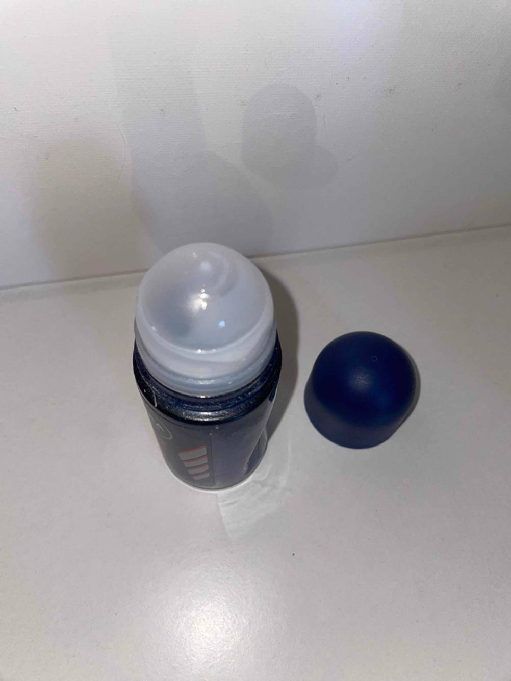Nahaufnahme der Kugel eines geöffneten Deo-Roller für Herren auf einer hellen Fläche.