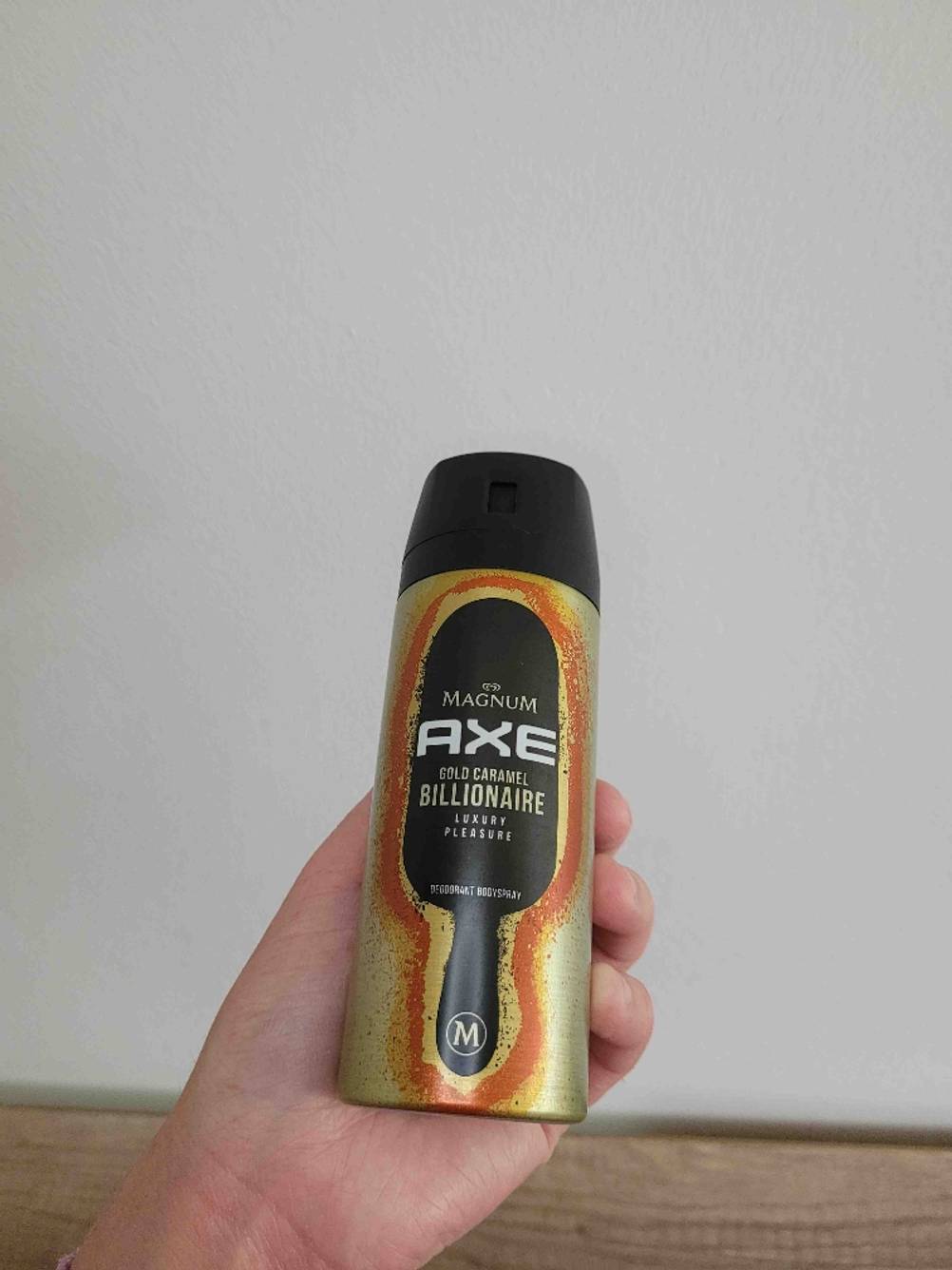 Eine Hand hält eine Dose des getesteten Deos vor eine helle Wand.
