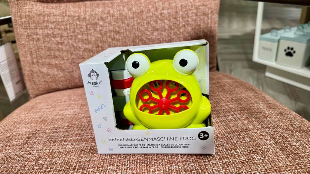 Eine verpackte Seifenblasenmaschine für Kinder steht zum testen auf einem Sessel.
