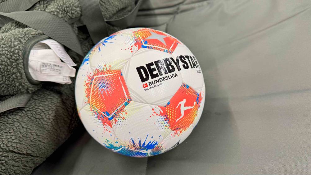 Auf einer grauen Decke liegt der getestete Derbystar-Fußball.