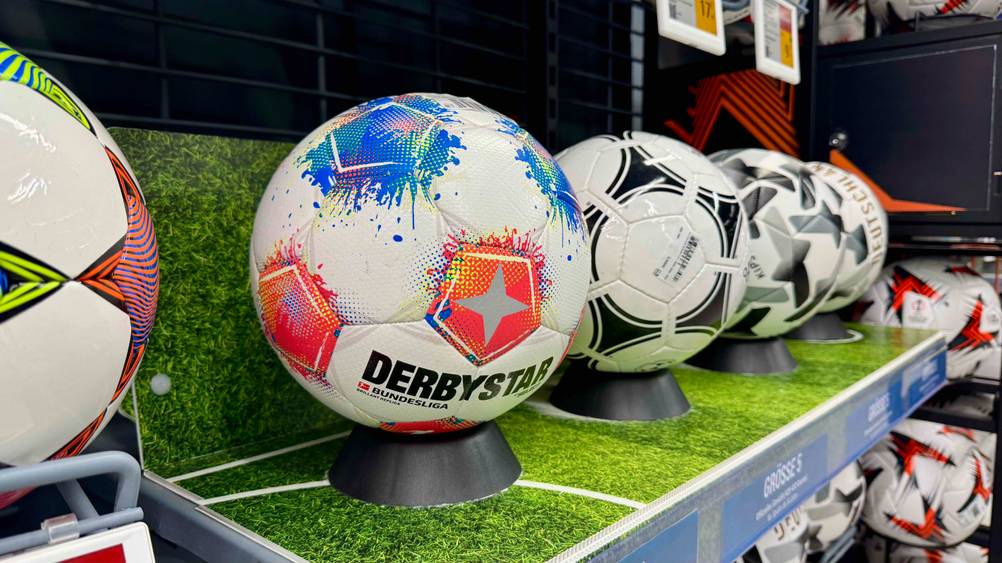 Derbystar-Fußball im Test: Ein Ball auf einem Ständer in einem Regal mit anderen Bällen.
