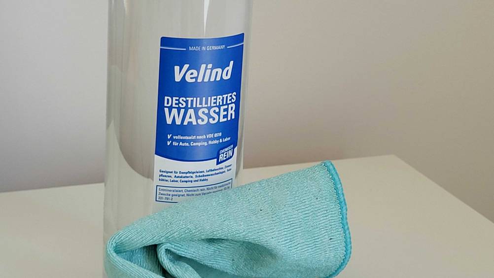 Nahaufnahme des Labels einer Flasche des getesteteten destillierten Wassers, davor ein Mikrofasertuch.