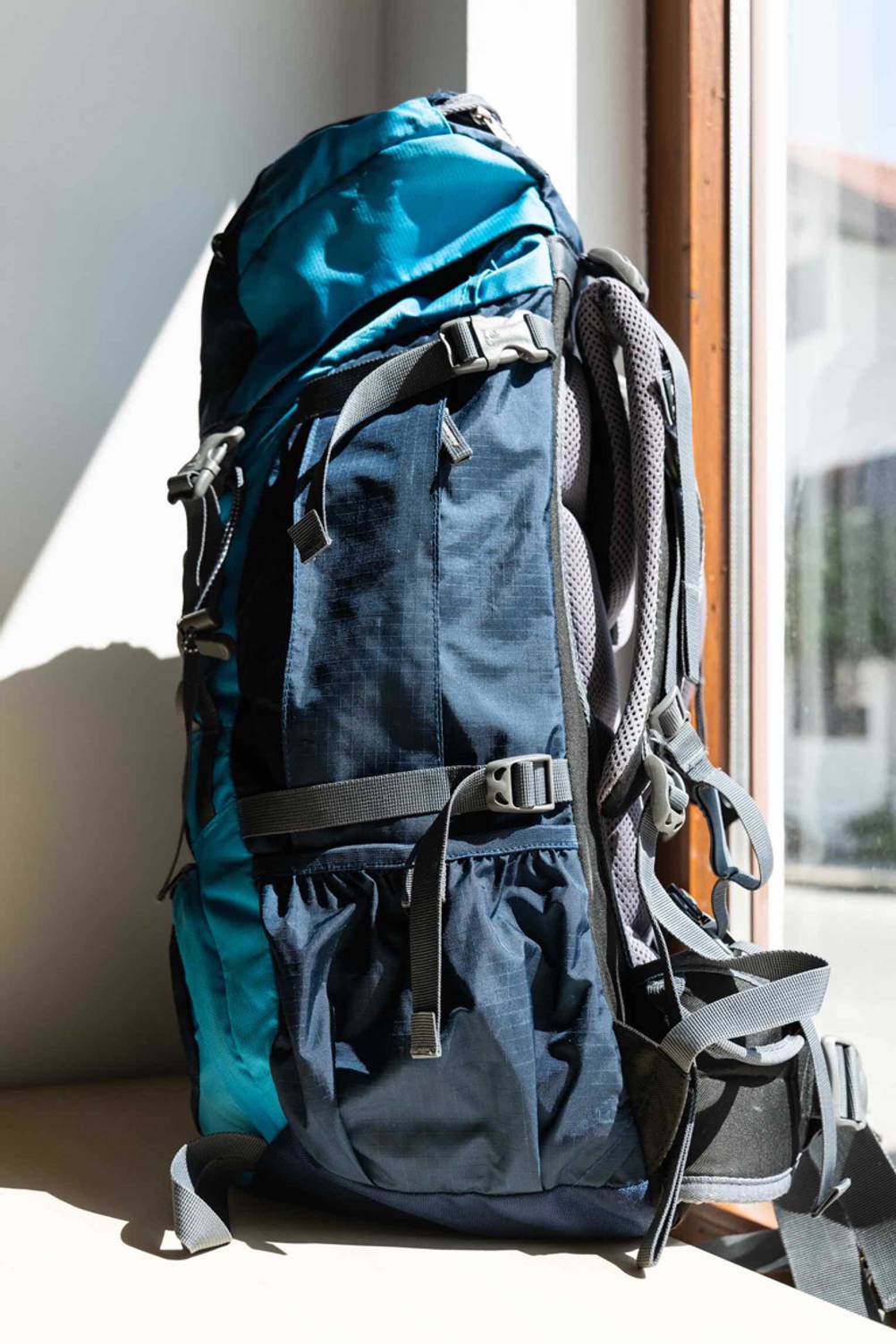 Backpacking-Rucksack-Test: Deuter-Backpacking-Rucksack von der Seite vor einem Fenster