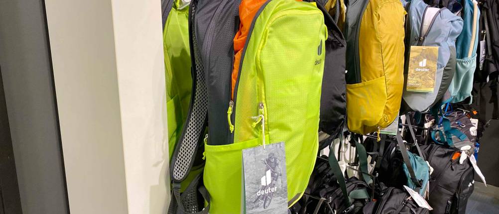 Im Test: Ein MTB-Rucksack in gelb-grau hängt neben anderen in einem Regal.