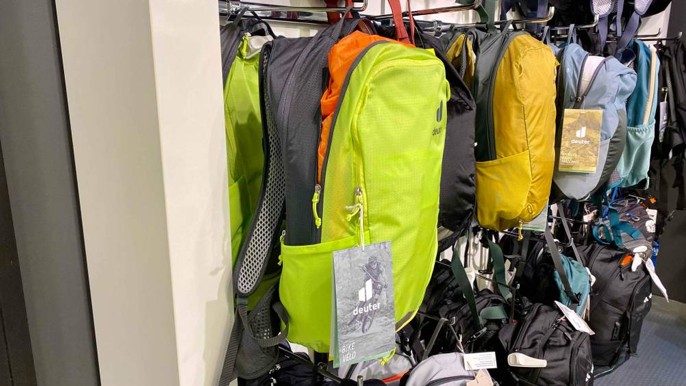 Im Test: Ein MTB-Rucksack in gelb-grau hängt neben anderen in einem Regal.