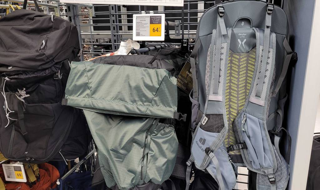 Ein Rucksack mit 25 Liter hängt getestet mit der Rückseite nach vorn in einem Gitterregal neben weiteren Säcken.