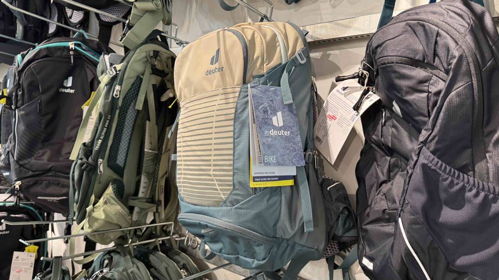Ein getesteter Deuter-Rucksack in einem Verkaufsregal neben anderen Produkten.