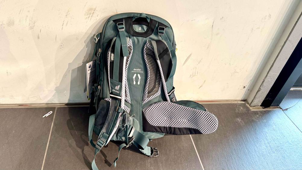 Ein getesteter Deuter-Rucksack lehnt an einer hellen Wand mit der Rückseite nach vorne.