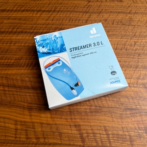 Der Karton der Deuter Streamer 3.0 l liegt auf einem Tisch