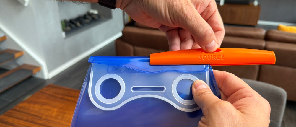 Eine Hand schiebt den Riegel auf den Verschluss der Deuter Streamer 3.0 l