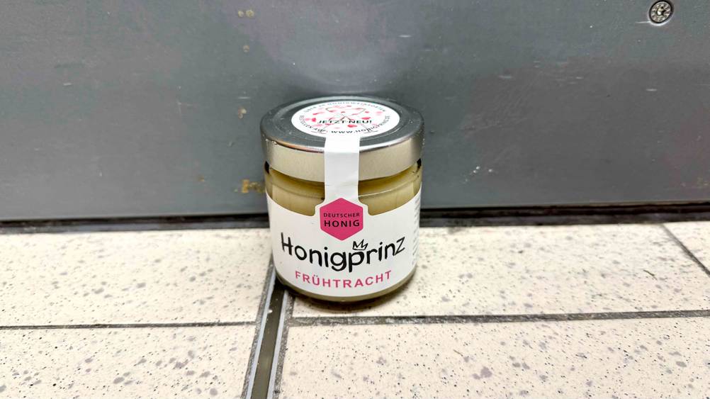 Deutscher Honig getestet: Ein Glas von schräg oben vor einer grauen Fläche am Boden stehend.