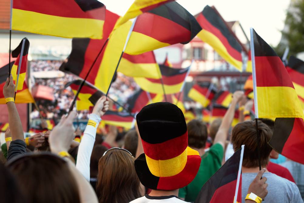 Menge beim Public Viewing mit Deutschland-Fahnen und Accessiores in den Farben der deutschen Flagge.