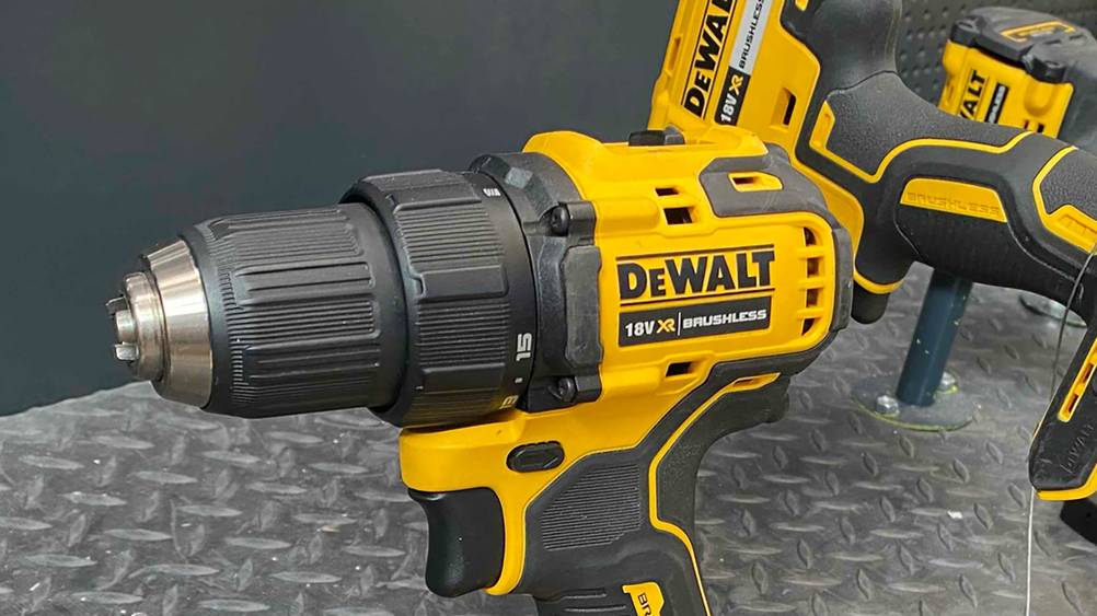 Nahaufnahme des Kopfes eines DeWalt-Akku-Bohrschraubers im Test, im Hintergrund andere Geräte.