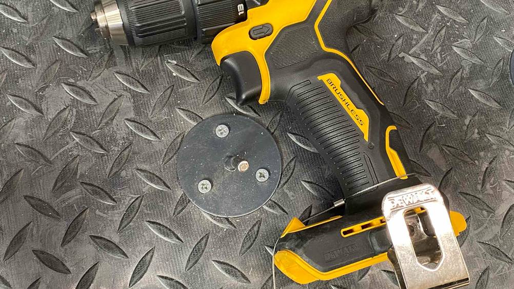 Nahaufnahme des Griffes eines getesteten DeWalt-Akku-Bohrschraubers auf einer dunklen Fläche.