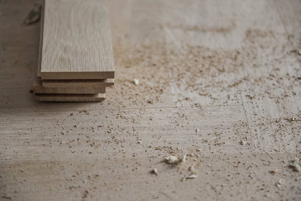 DeWalt-Kappsäge im Test: Holzboden mit zwei Dielenbrettern und Sägespänen.