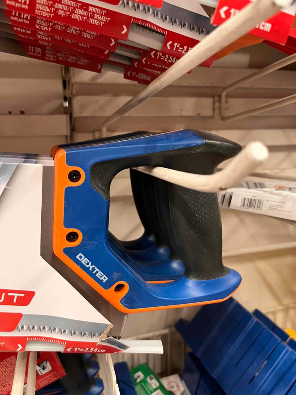 Detailaufnahme einer Dexter-Gehrungssäge im Test, mit Fokus auf den blau-orangen Handgriff mit schwarzer Gummierung im Griffbereich.