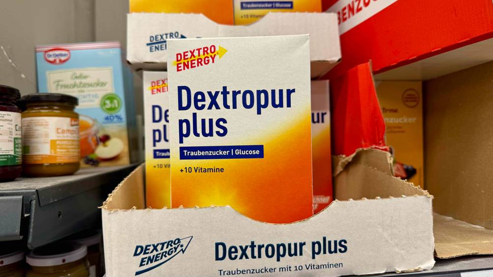 Mehrere Packungen des getesteten Dextro Energy in einem Karton in einem Verkaufsregal.