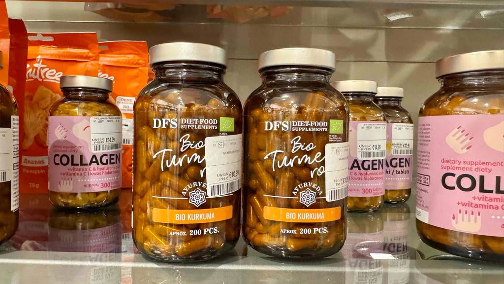 Bio-Kurkuma-Kapseln im Test: Mehrere Gläser stehen zwischen anderen Produkten in einem Regal.