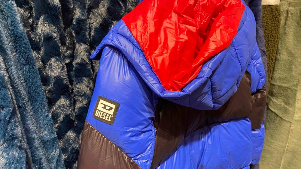Im Test: Nahaufnahme des Logos und der Kaputze einer Kinder-Winterjacke für Jungen.