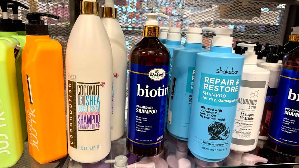 Biotin-Shampoo-Test: Ein Spender steht zwischen weiteren Shampoo-Spendern auf einem Verkaufsregal.