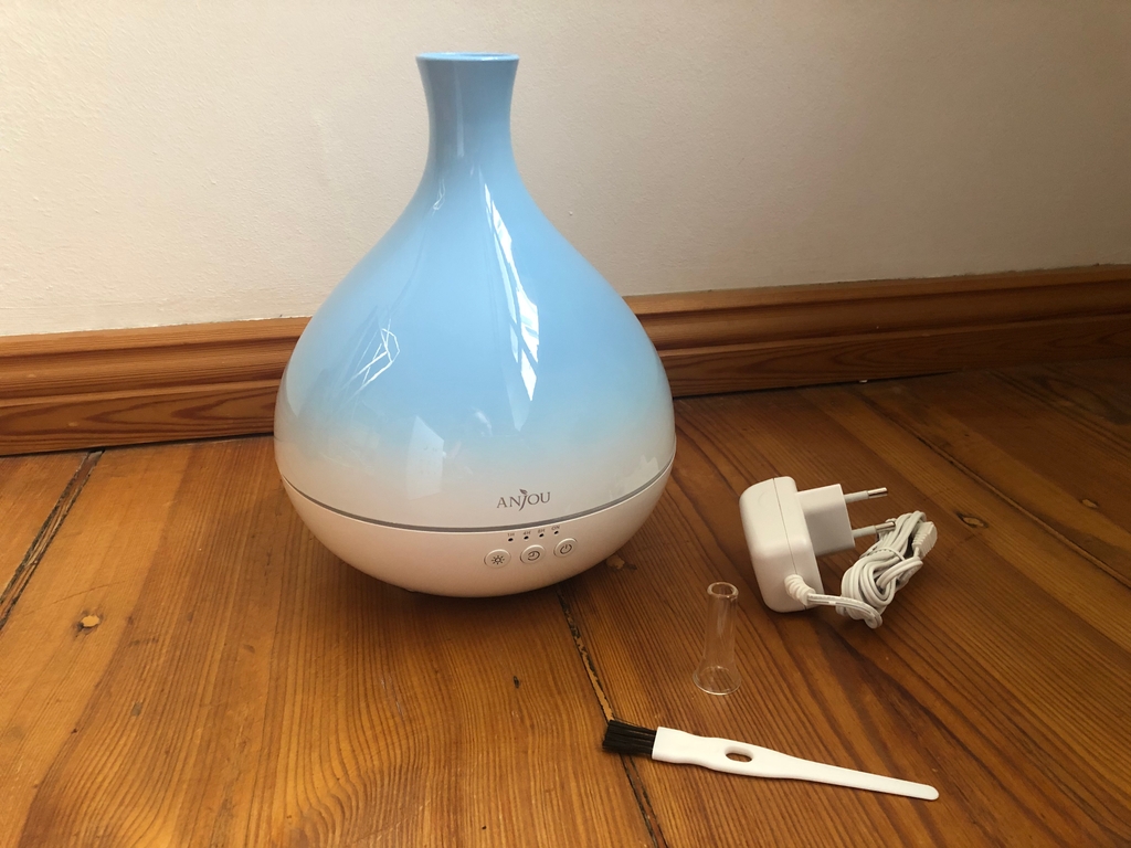 Diffuser auf dem Holzboden mit Ladegerät und Reinigungspinsel