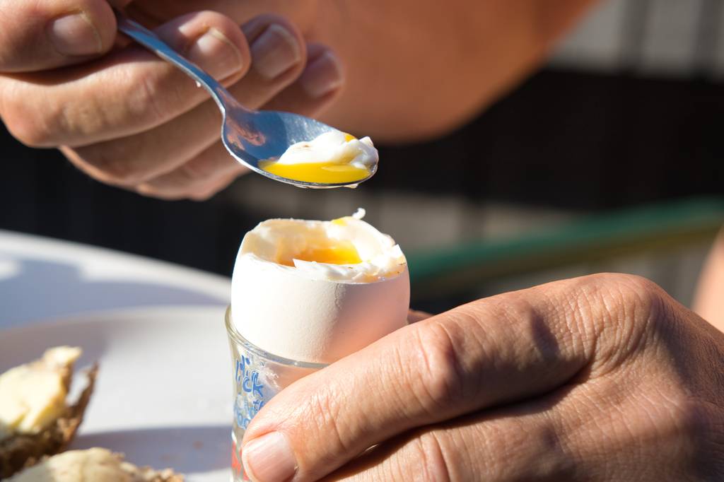 Digitaler Kurzzeitwecker Test: Ein Frühstücksei wird mit einem kleinen Löffel gegessen. 