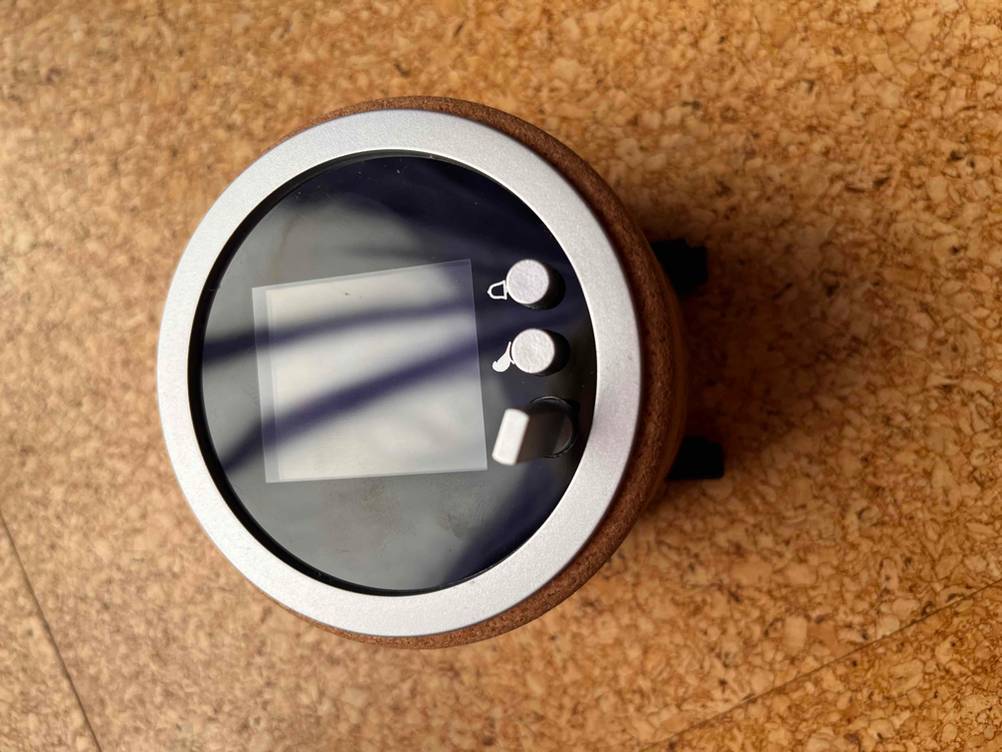 Auf dem Boden befindet sich ein getesteter digitaler Wecker mit Display und Timerfunktion. 