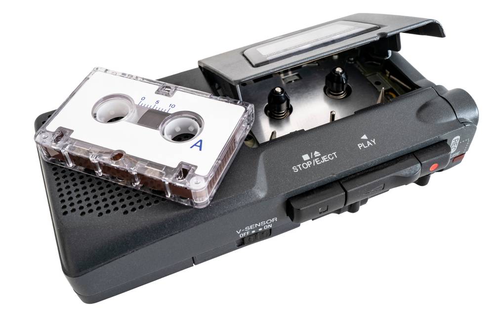 Ein getestetes analoges Diktiergerät, auf dem eine Kassette liegt.