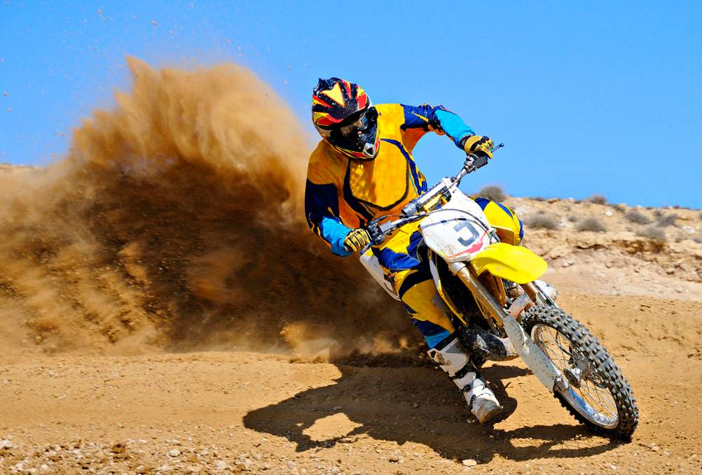 Ein Dirtbike-Fahrer wirbelt Staub auf.