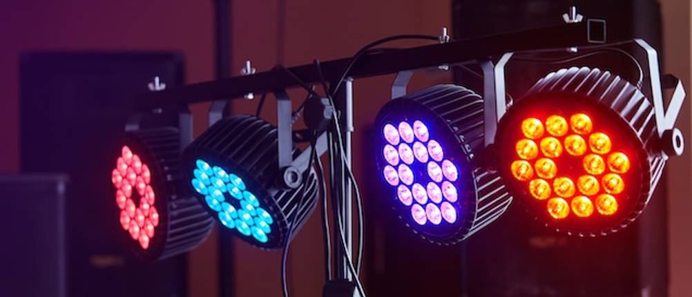 Disco-Licht-Test: Vier Strahler mit LED-Leuchten mit verschiedenen Farben hängen an einer Traverse.
