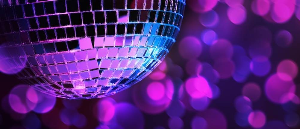 Disco-Licht-Test: Eine Disco-Kugel vor violetten Leuchtpunkten.