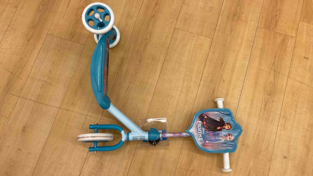 Im Test: Ein Disney-Frozen-Kinder-Scooter liegt auf der Seite auf einem Holzboden.