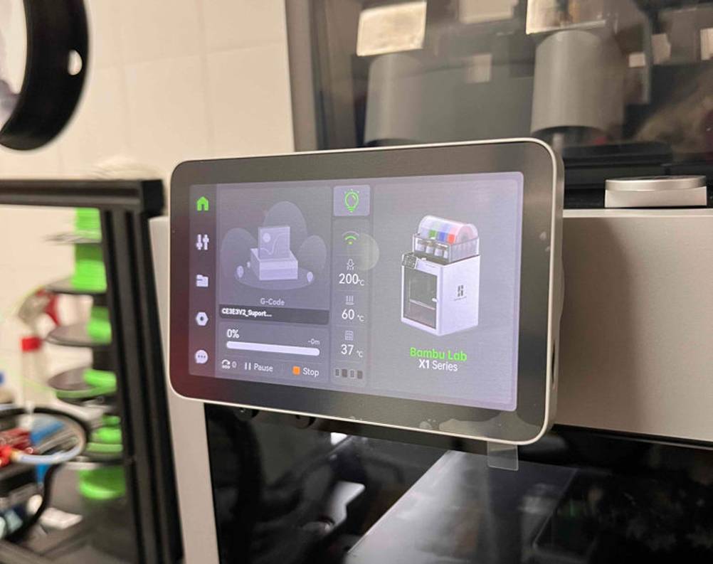 Nahaufnahme des Farb-Displays mit Kommandopaneel von einem eingeschalteten Bambu Lab 3D-Drucker im Test.