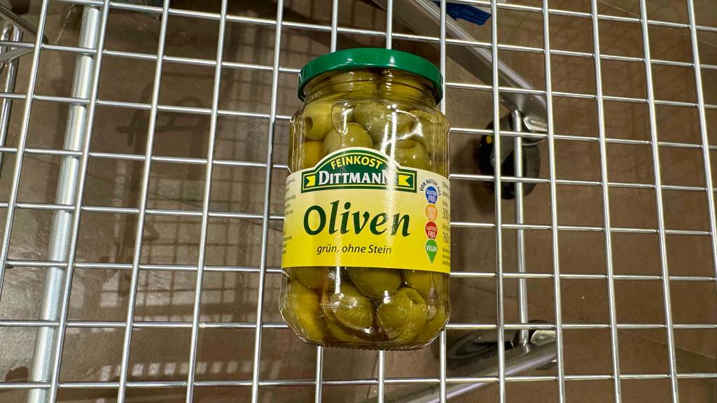 Oliven im Glas-Test: Ein Glas liegt in einem Einkaufswagen.
