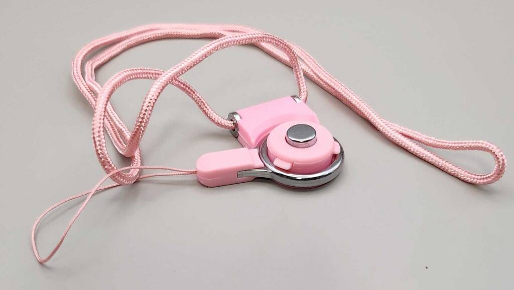 Kinderkameras im Test: Ein rosa Fernauslöser mit Kordel liegt auf einer weißen Oberfläche.