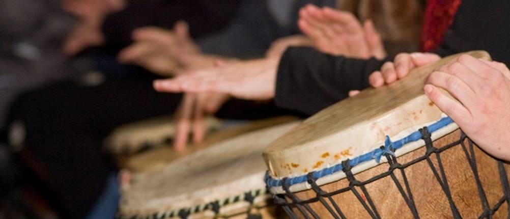 Djembe-Test in einem Workshop mit mehreren Spielern in Nahaufnahme beim Spielen des Instruments.