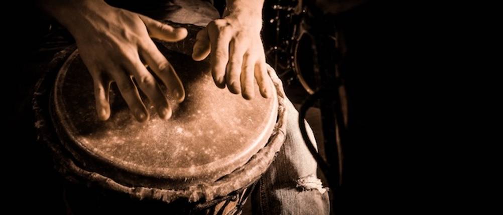 Djembe-Test: Nahaufnahme von Händen, die eine Djembe spielen.